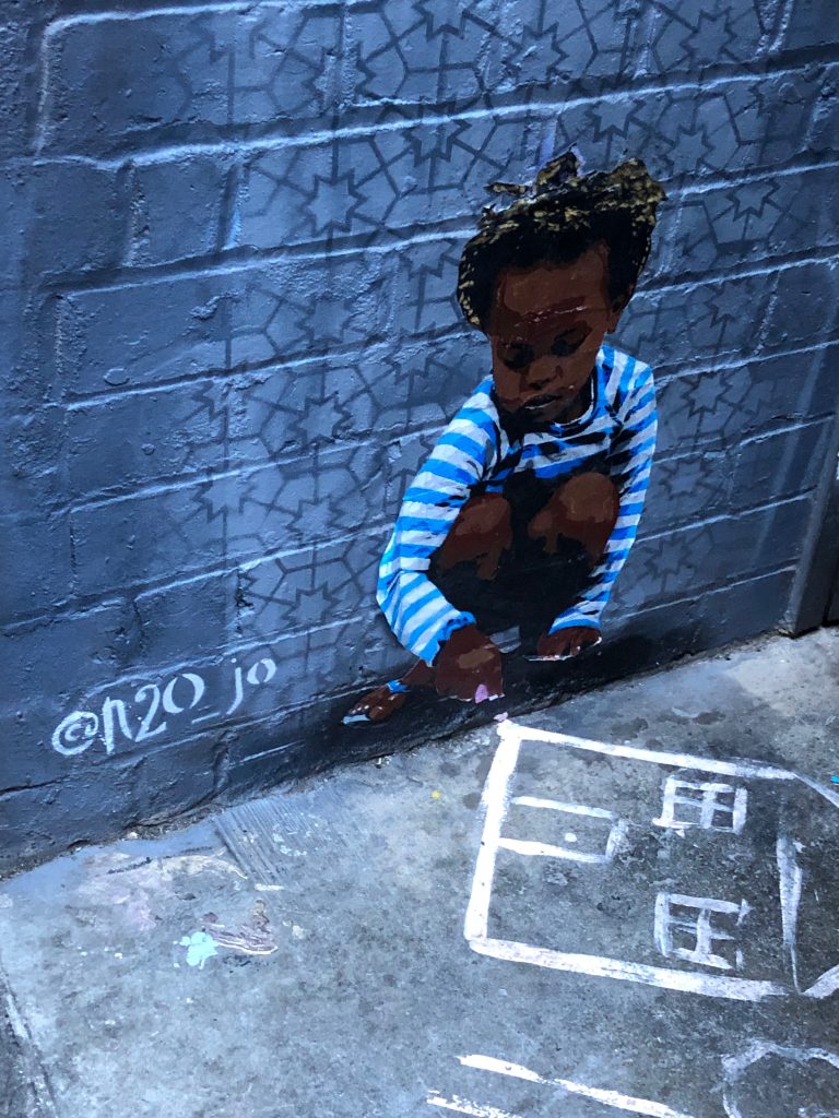 Street art of a child drawing by @n20_jo in Melbourne, Australia